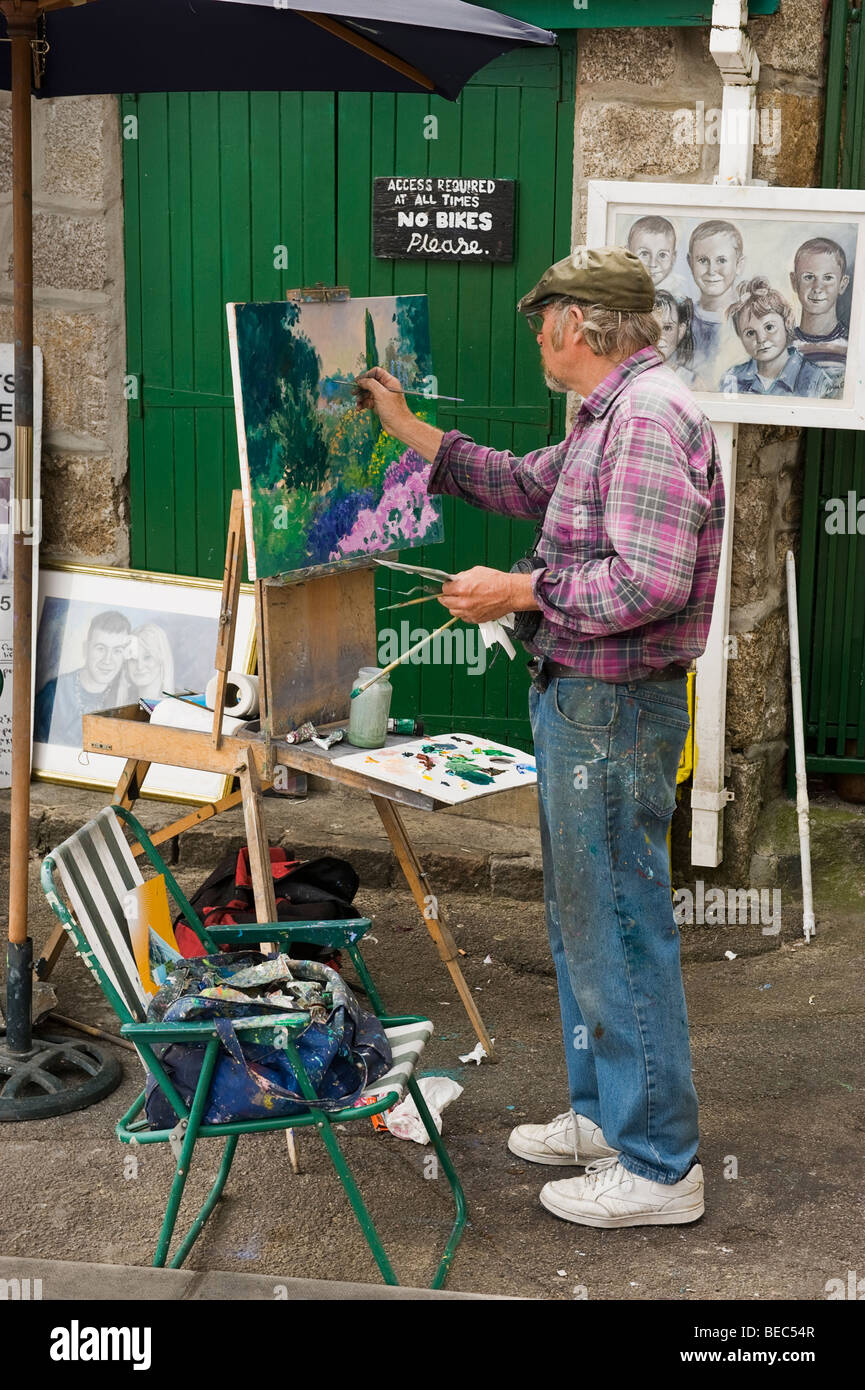 Un artista di strada dipinto una tela su un cavalletto in St Ives, Cornwall, Regno Unito Foto Stock