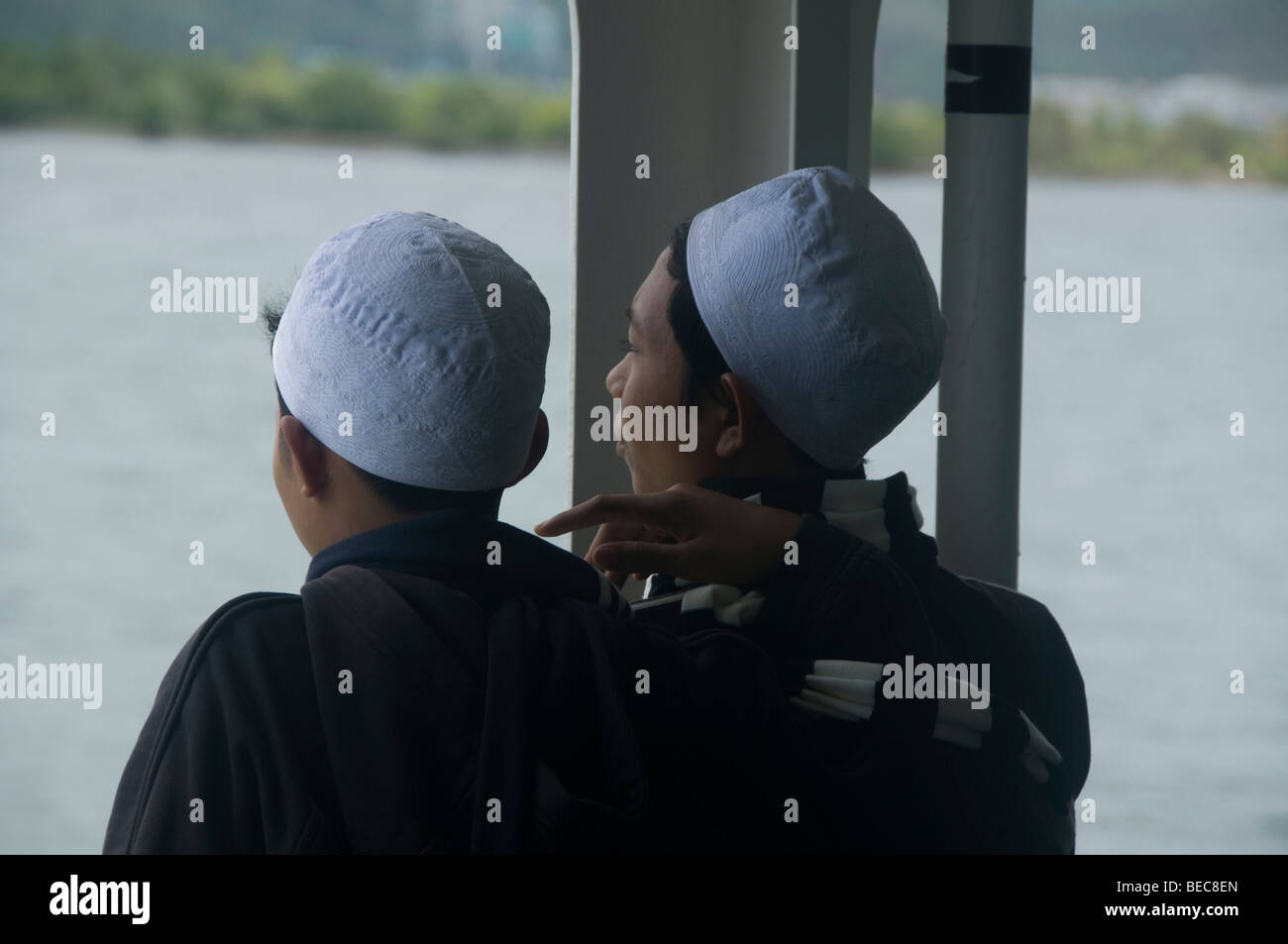 Ragazzi musulmani con skullcaps sul traghetto da Bali a Lombok in Indonesia Foto Stock