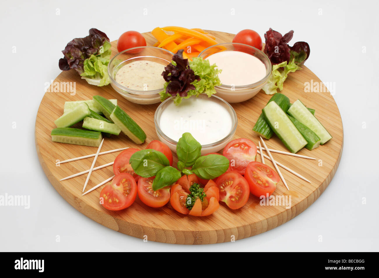 Miniatura capsicum, cocktail pomodori a fette, cetriolino in miniatura, lattuga, salsa di yogurt, American dip, senape-miele dip su un woo Foto Stock