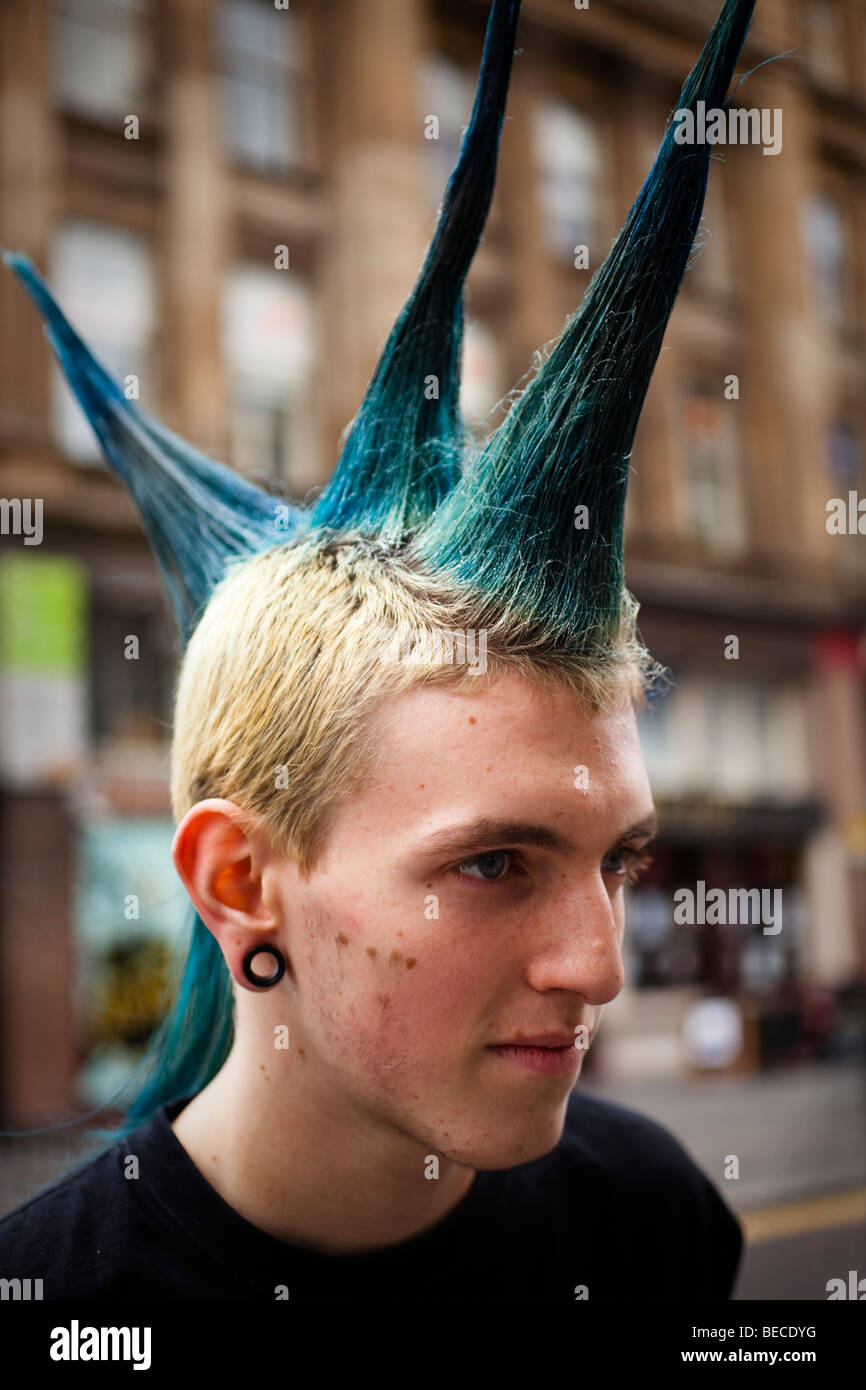 Giovane uomo punk con colorate e capelli pungenti. Fotografato nel centro della città di Glasgow Foto Stock