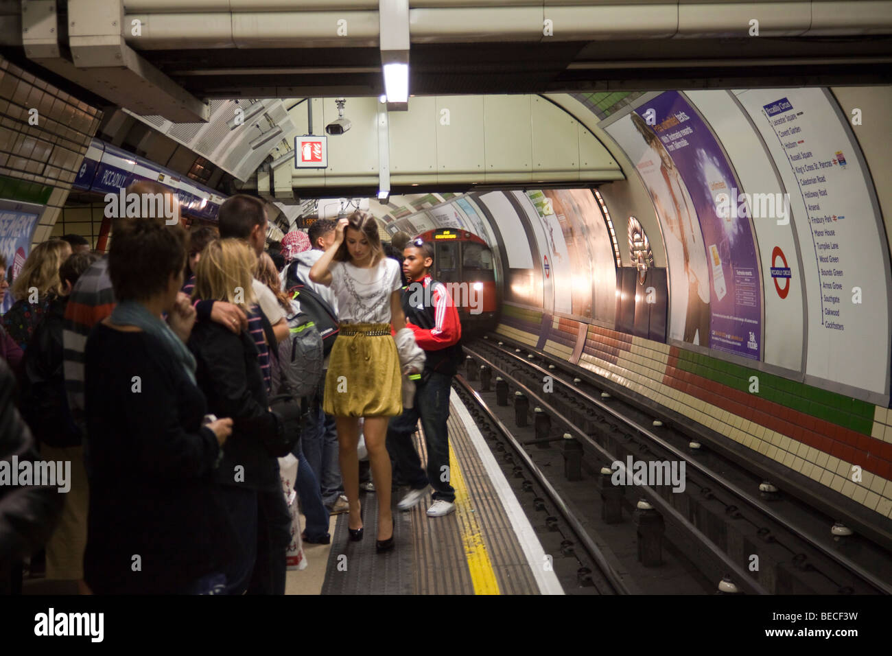 Piattaforma affollate, treno in arrivo, Piccadilly Circus, la metropolitana di Londra, London, England, Regno Unito Foto Stock