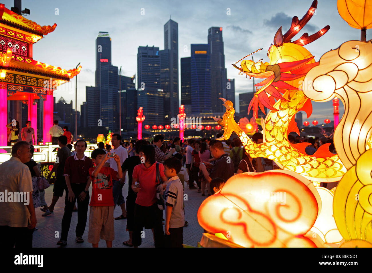 Il fiume Singapore Hong Bao carnivale con draghi illuminato e figure per il nuovo anno cinese di fronte allo skyline di Foto Stock