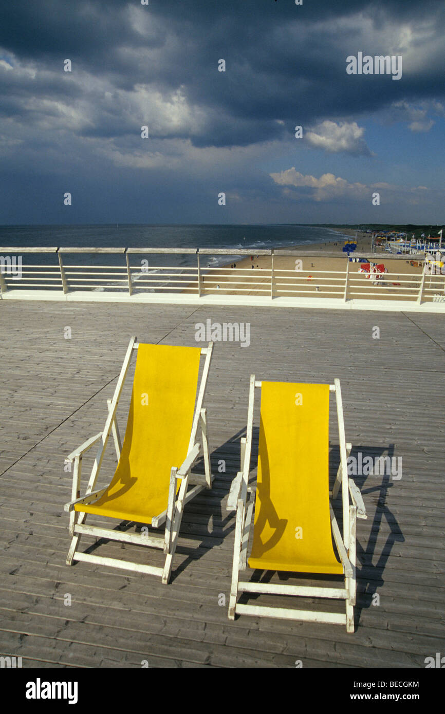 Due sdraio giallo su De Scheveningse Pier, vista sulla spiaggia di Scheveningen, un sofisticato centro balneare vicino Foto Stock