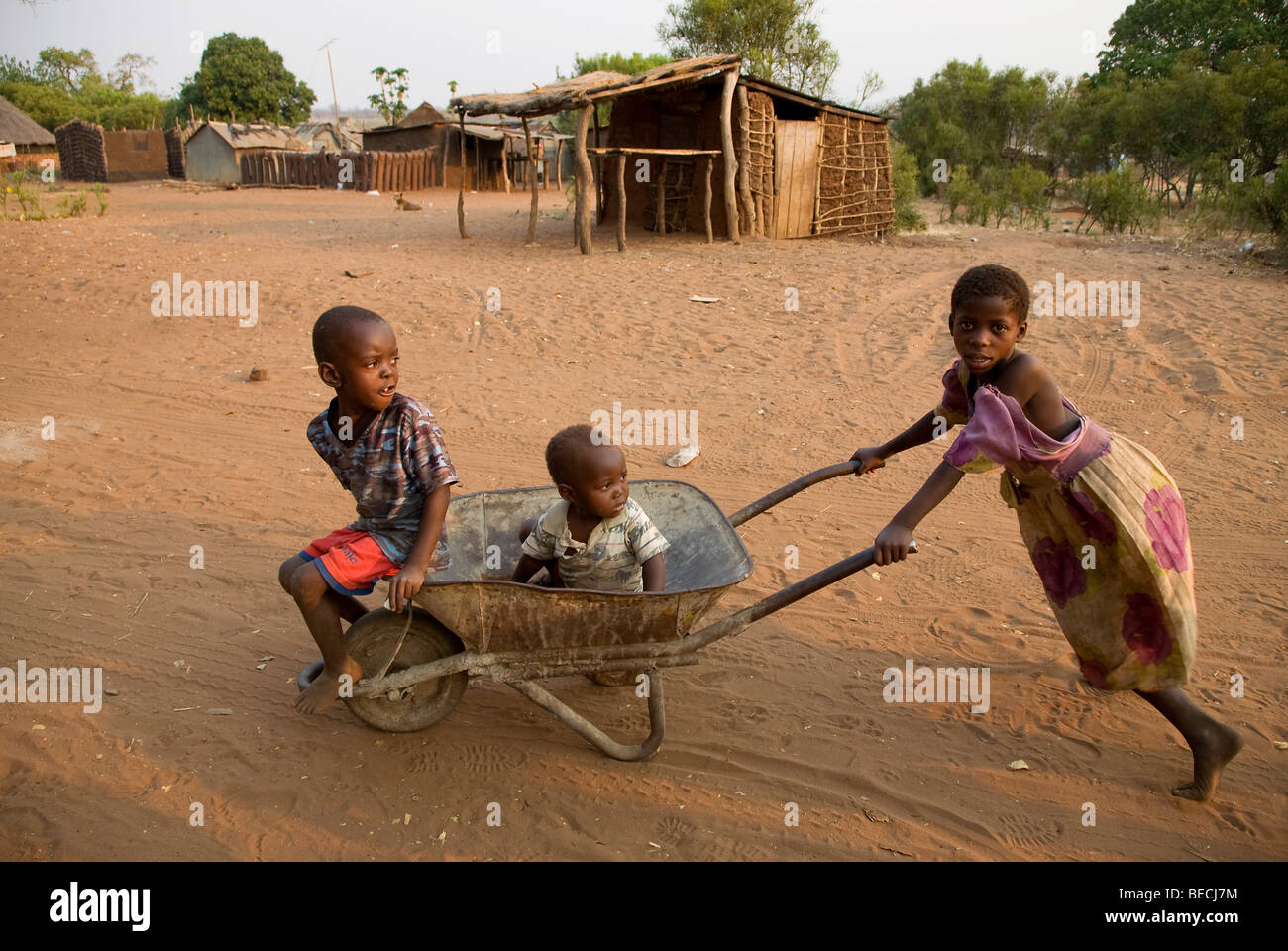 Bambini che giocano con una ruota di Barrow, villaggio africano Sambona, sud della provincia, la Repubblica di Zambia e Africa Foto Stock