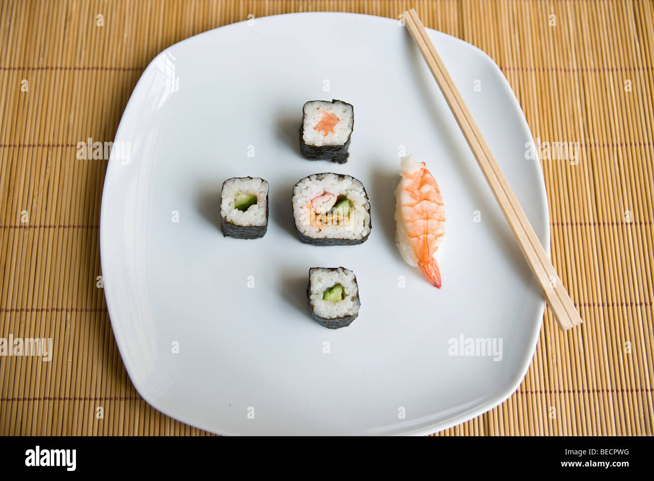Diversi tipi di sushi e bacchette su una piastra Foto Stock
