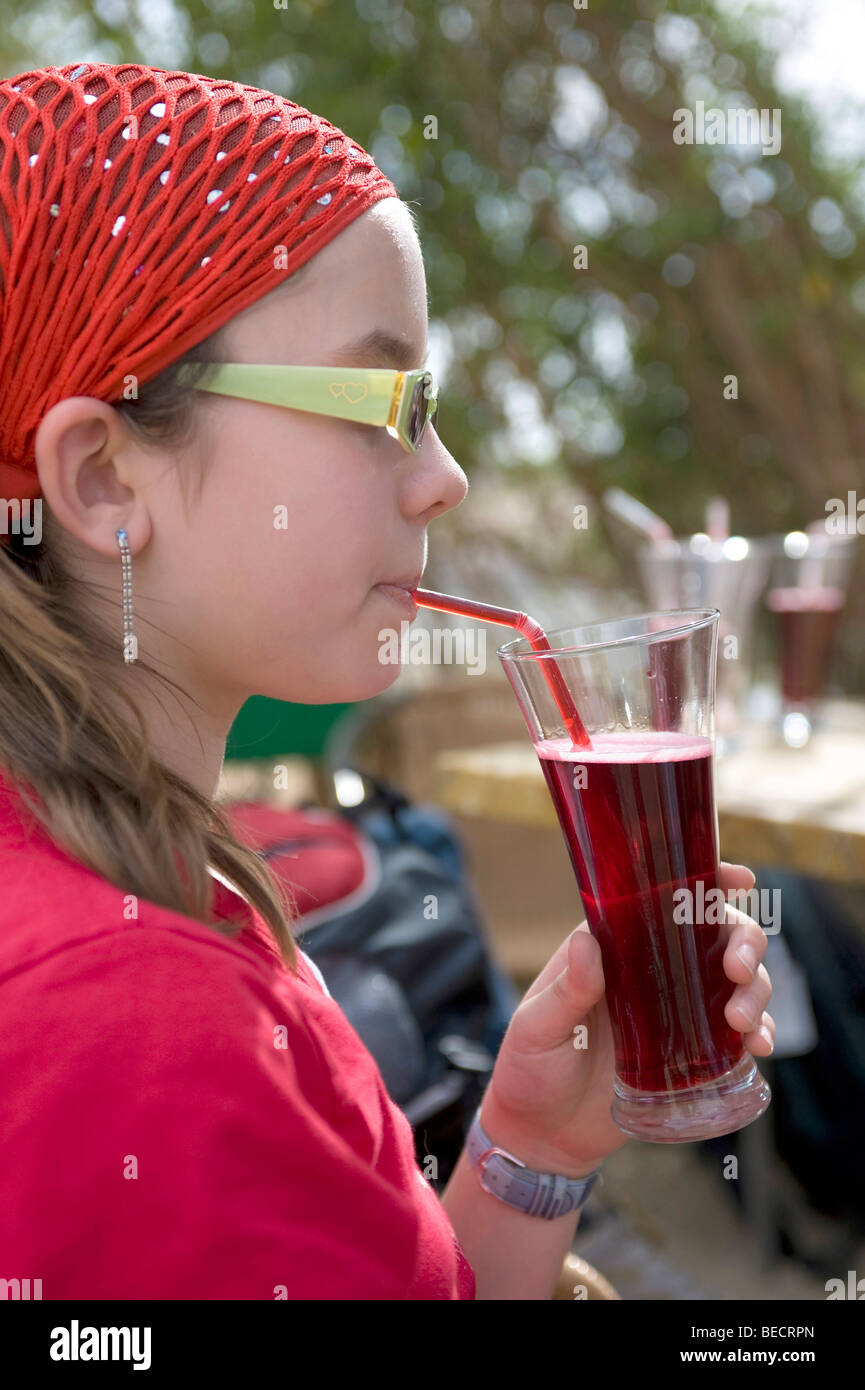 Ragazza europea bere egiziane di bevanda nazionale Karkady, hibiscus tea, Luxor, Egitto Foto Stock