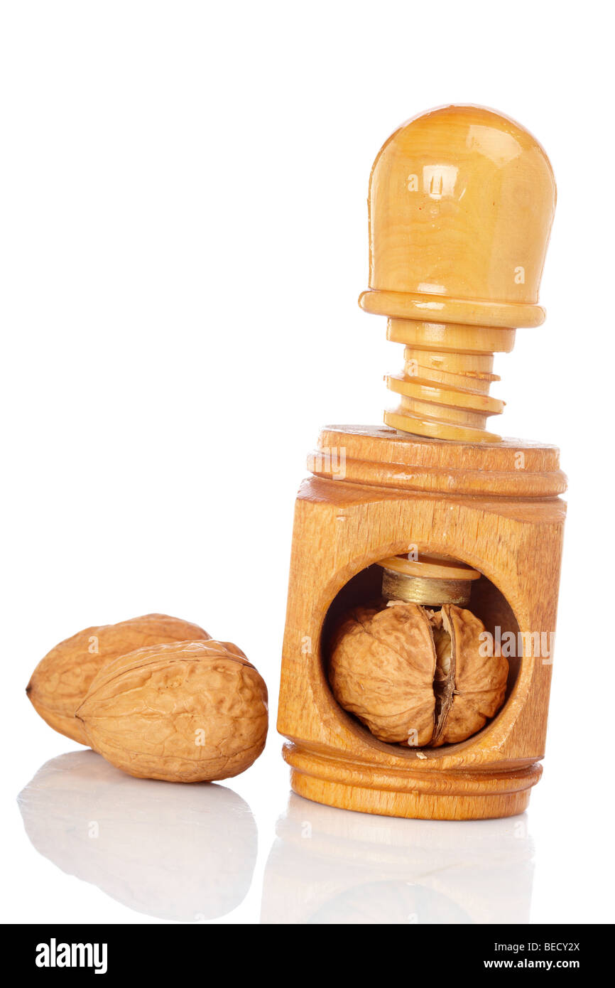 Alcune noci e schiaccianoci di legno riflette su sfondo bianco Foto Stock