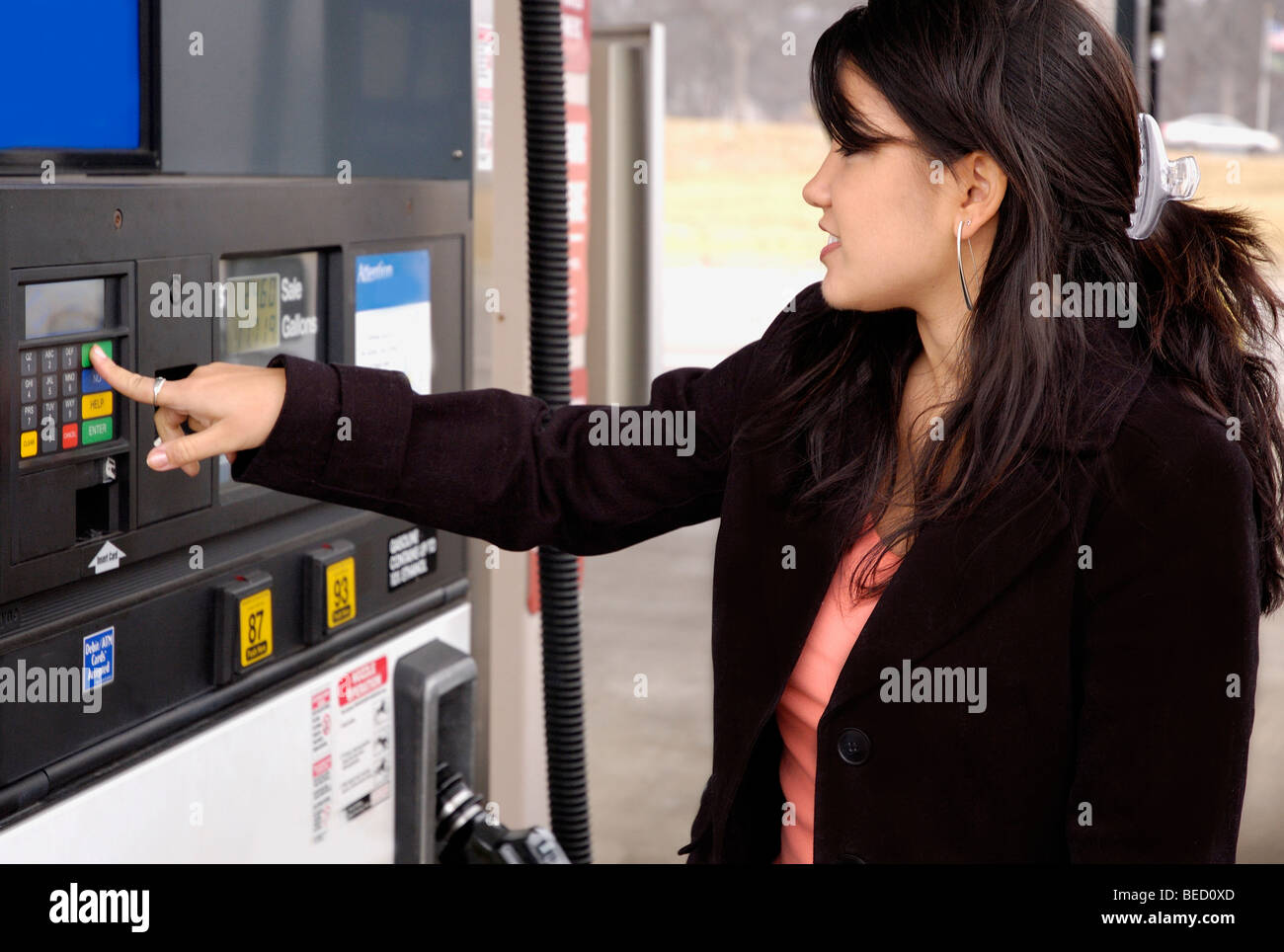 Giovane donna alla stazione di gas, gas pompa. Foto Stock