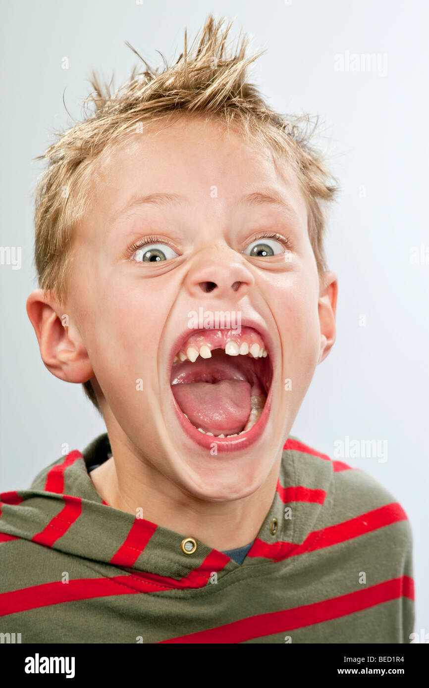 Ritratto di un 7-anno-vecchio ragazzo con un dente divario tirando una faccia Foto Stock