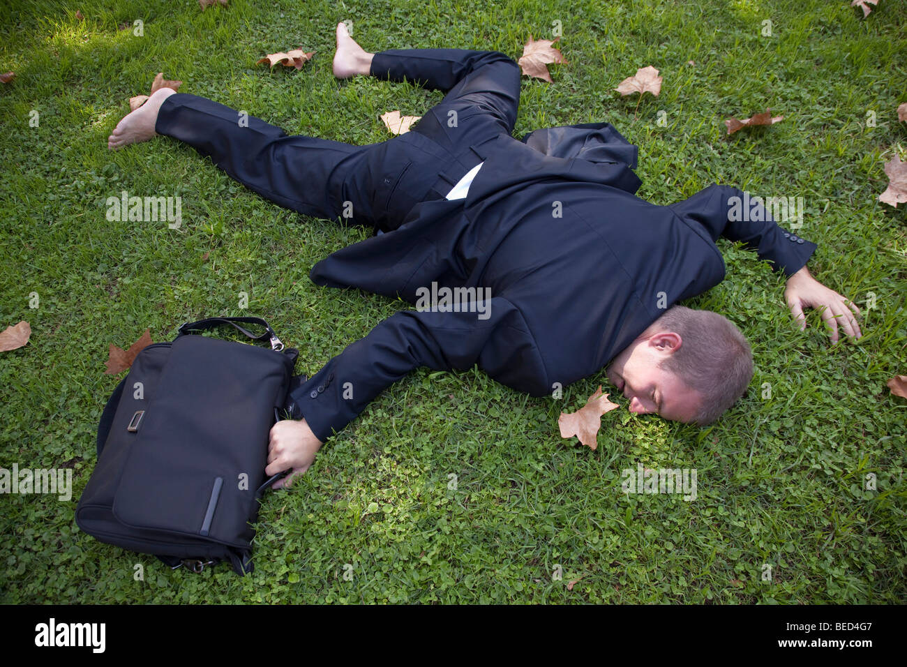 Businesman caduto piatto sull'erba Foto Stock