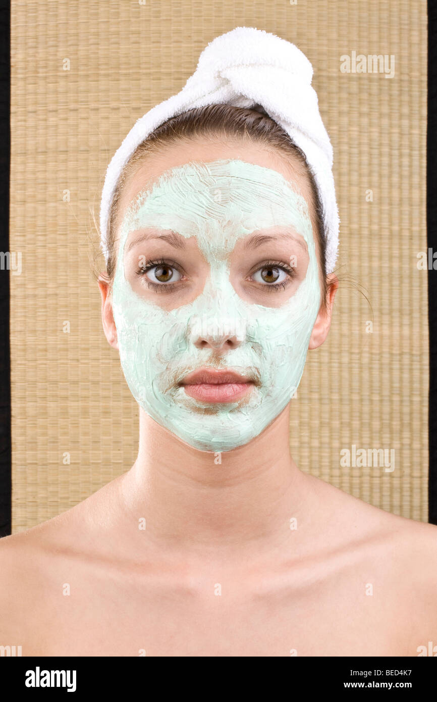 Giovane donna con una maschera per il viso Foto Stock