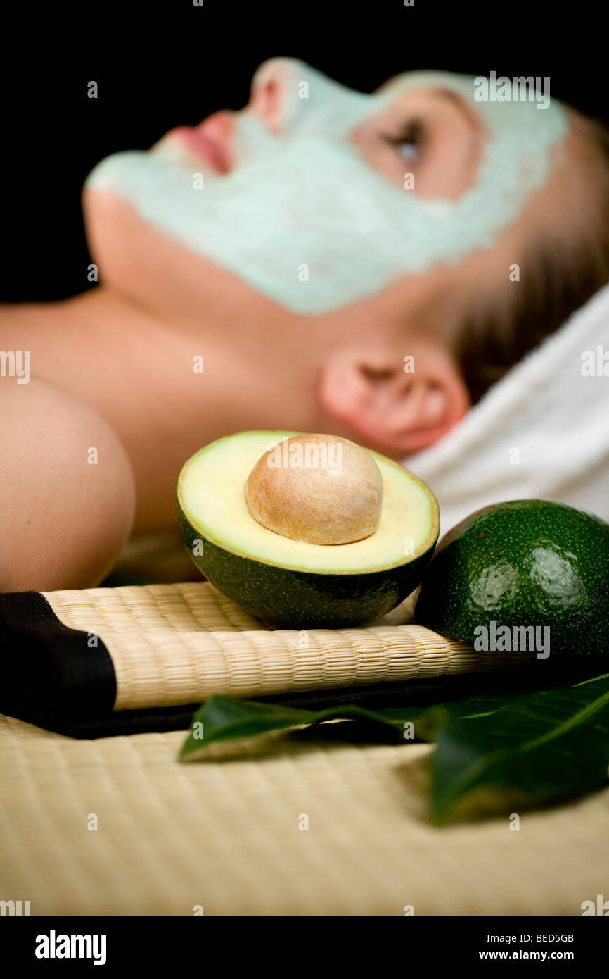 Giovane donna con un viso maschera di avocado Foto Stock