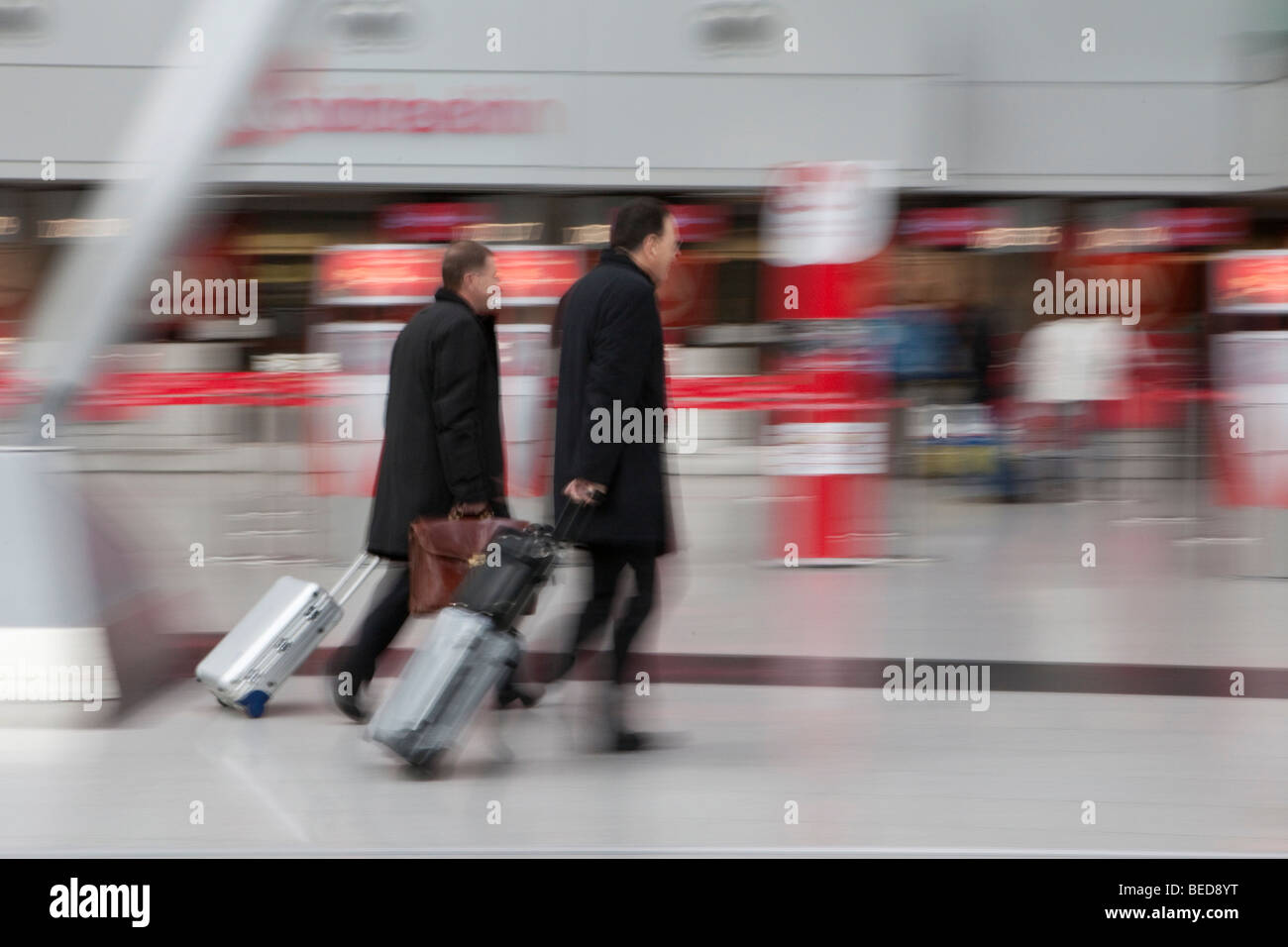 Immagine sfocata, imprenditori rapidamente a piedi con i bagagli nella sala partenze presso l'aeroporto di Dusseldorf, Duesseldorf, Renania del Nord- Foto Stock