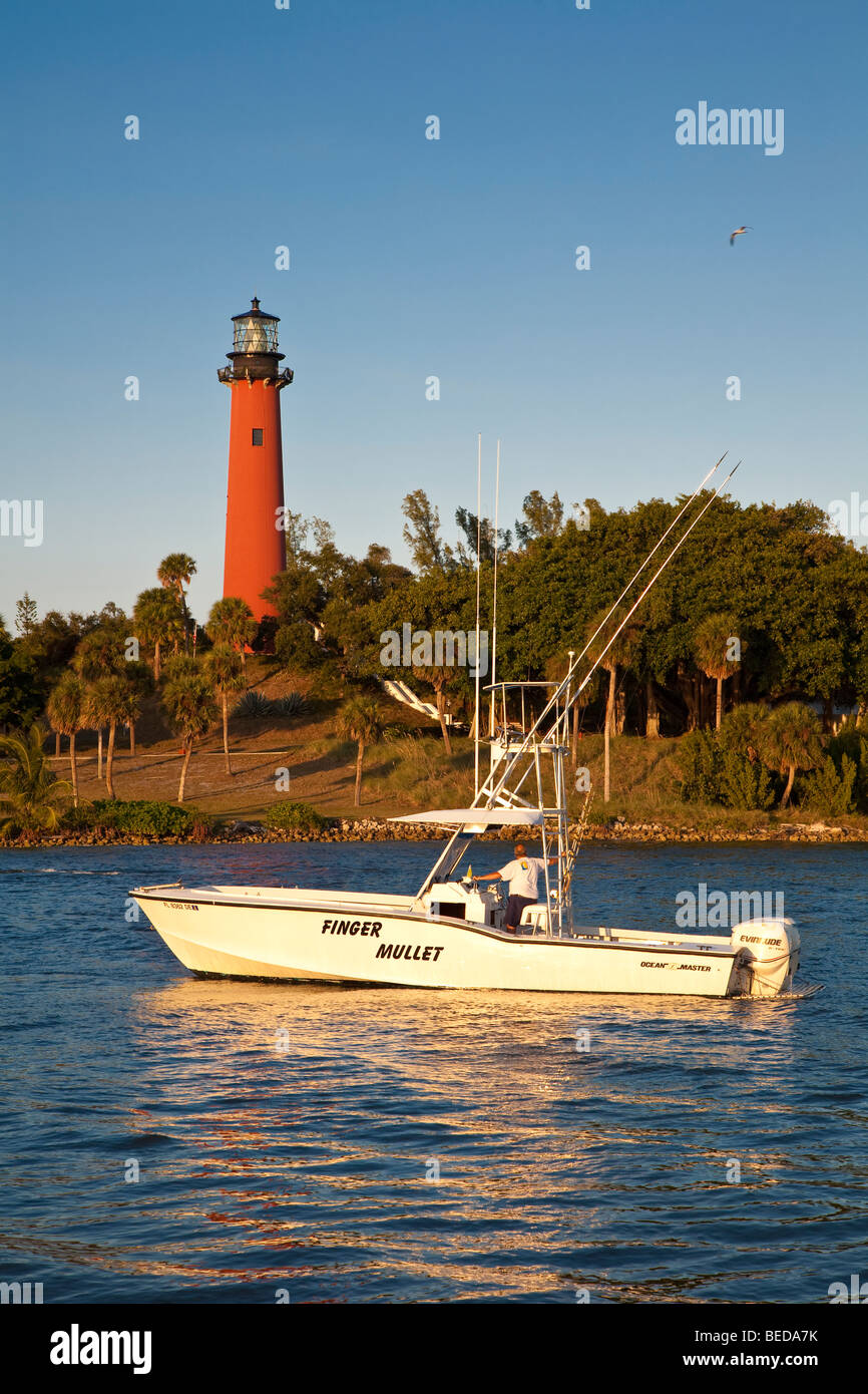 Privato barca da pesca passa faro rosso a Giove ingresso lungo la Florida's Oceano Atlantico litorale Foto Stock