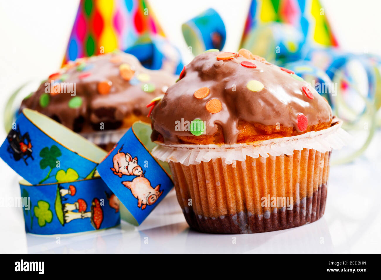 Muffin e carta streamers, immagine simbolica di carnevale o di compleanno di bambini Foto Stock