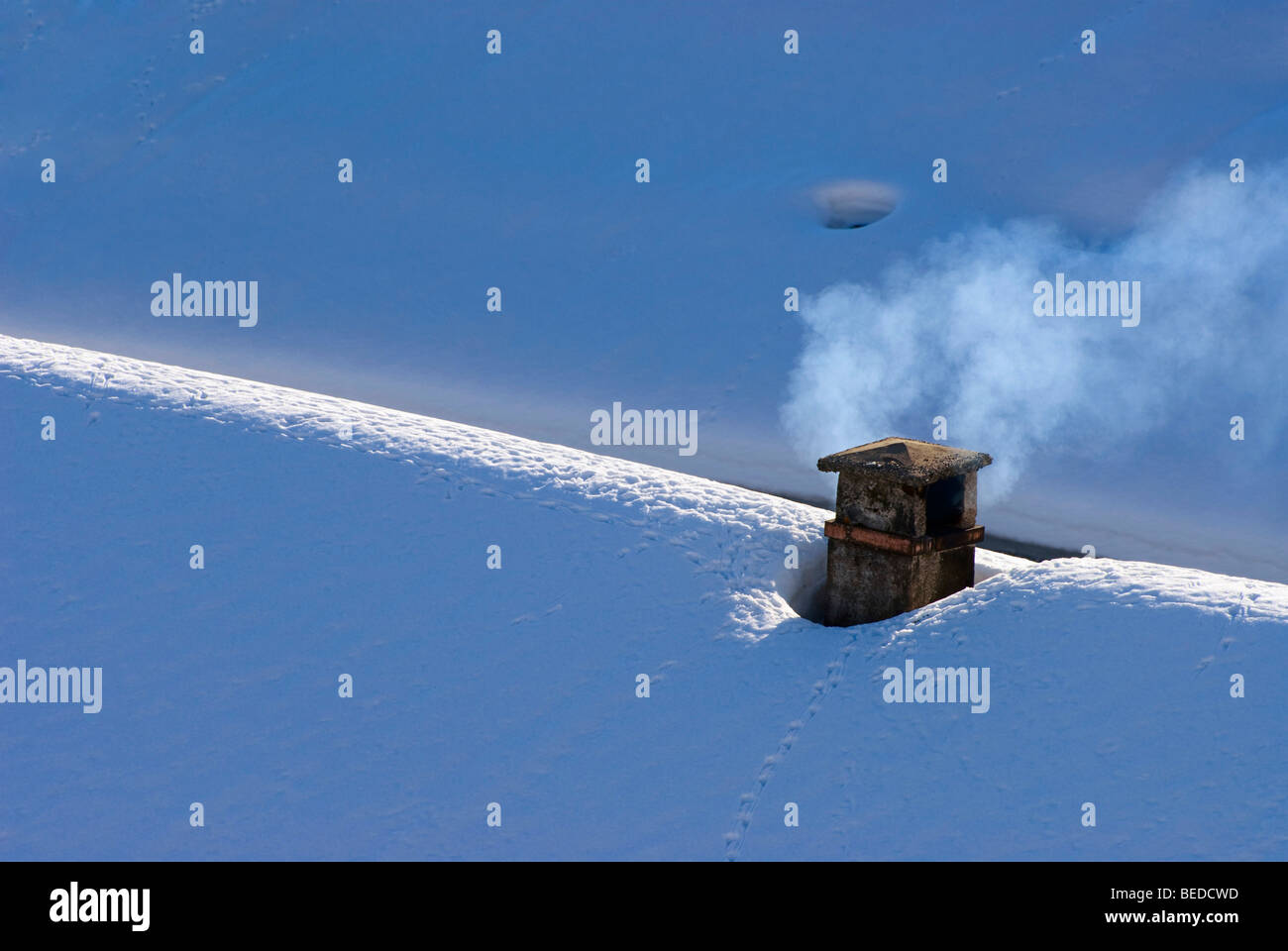 Fumatori camino su una coperta di neve sul tetto, dei Grigioni, Svizzera, Europa Foto Stock
