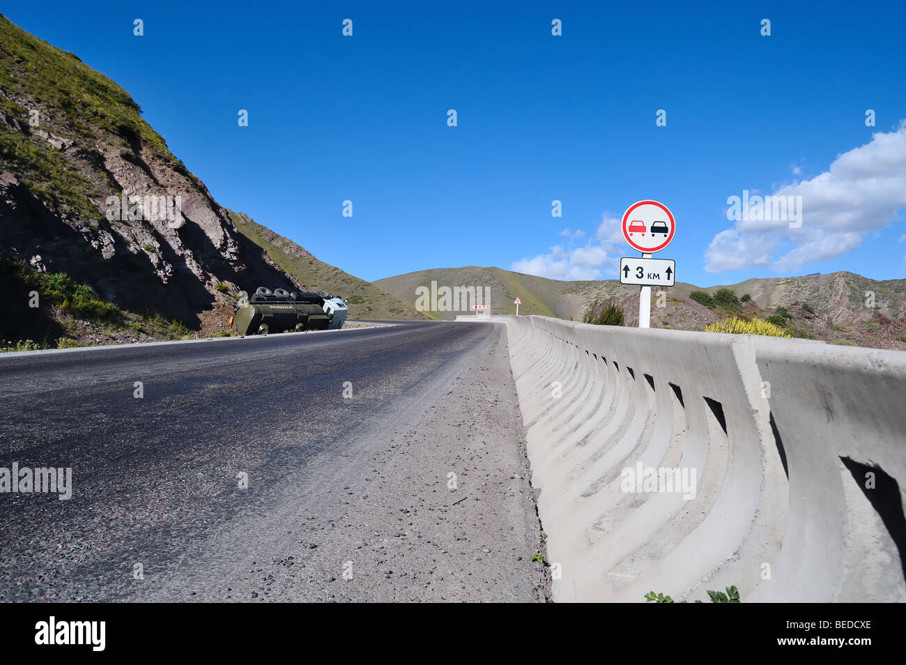 Cartello stradale e via incidente sulla strada di montagna in Kirghizistan. Foto Stock