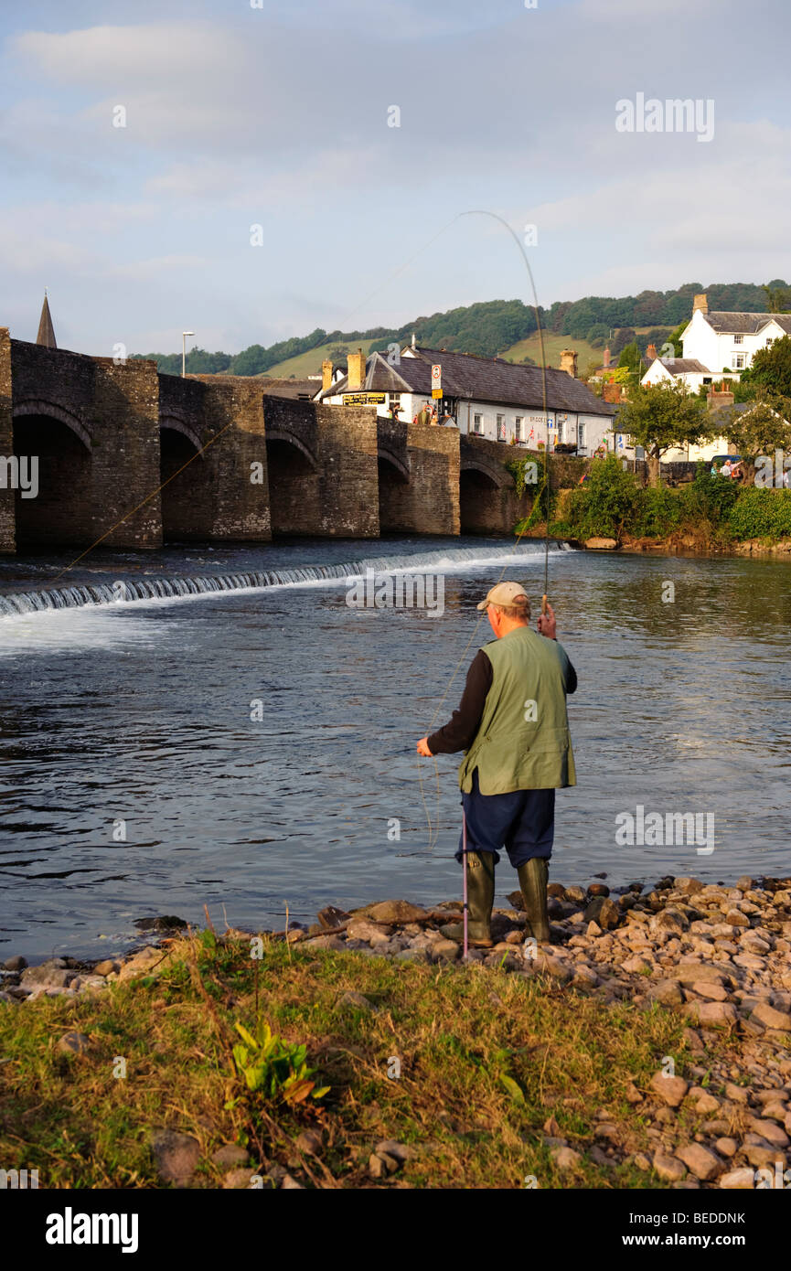 Un uomo di mezza età di Pesca a Mosca Report di Pesca vicino al vecchio ponte sul fiume Usk a Crickhowell, Powys Mid Wales UK Foto Stock