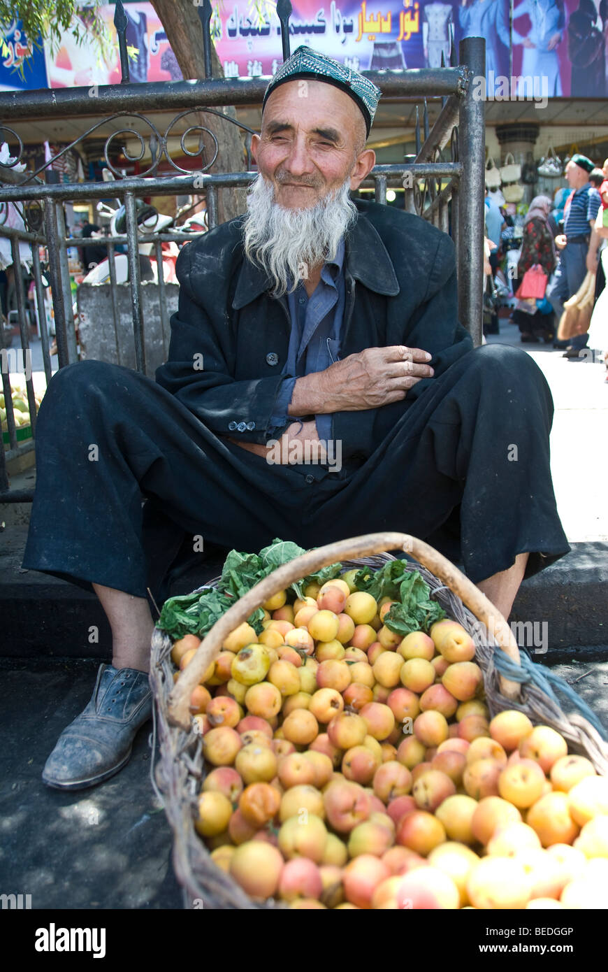 Local Uighur venditore a vendere fresche Albicocche in un mercato di Kashgar, provincia dello Xinjiang, Cina 2008. Foto Stock