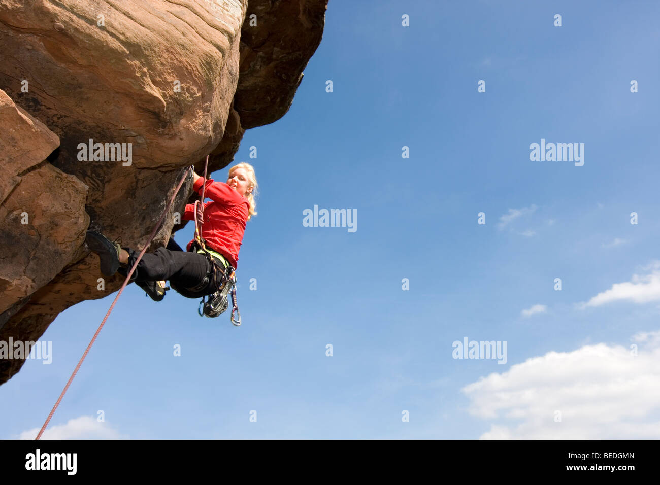 Giovane donna sorridente arrampicata roccia arenaria Foto Stock