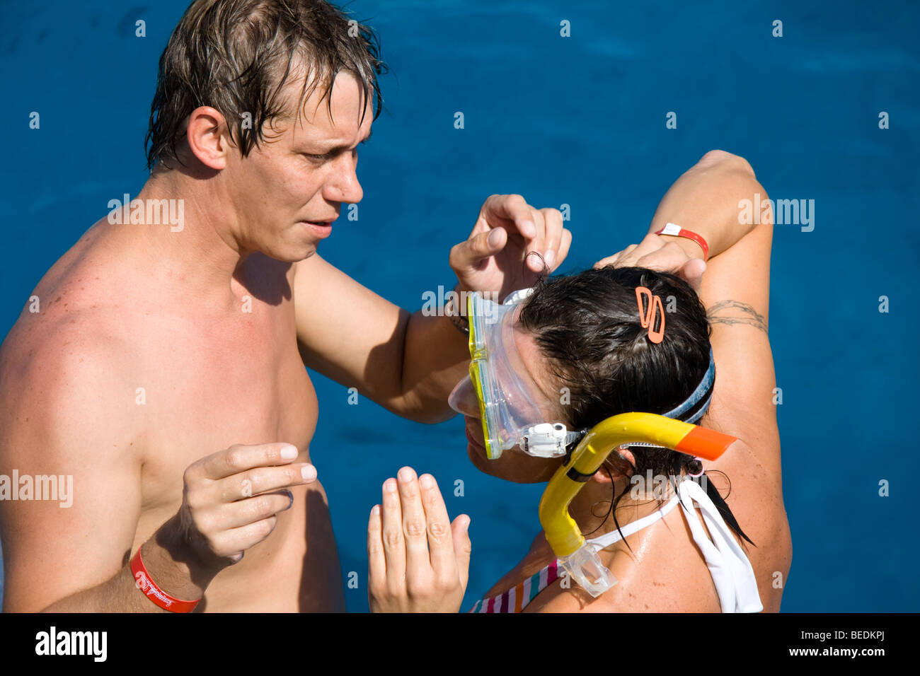 L'uomo aiutando una donna mettere su una maschera subacquea pronto per praticare lo snorkeling a Sharm el Sheikh, Mar Rosso, Egitto Foto Stock