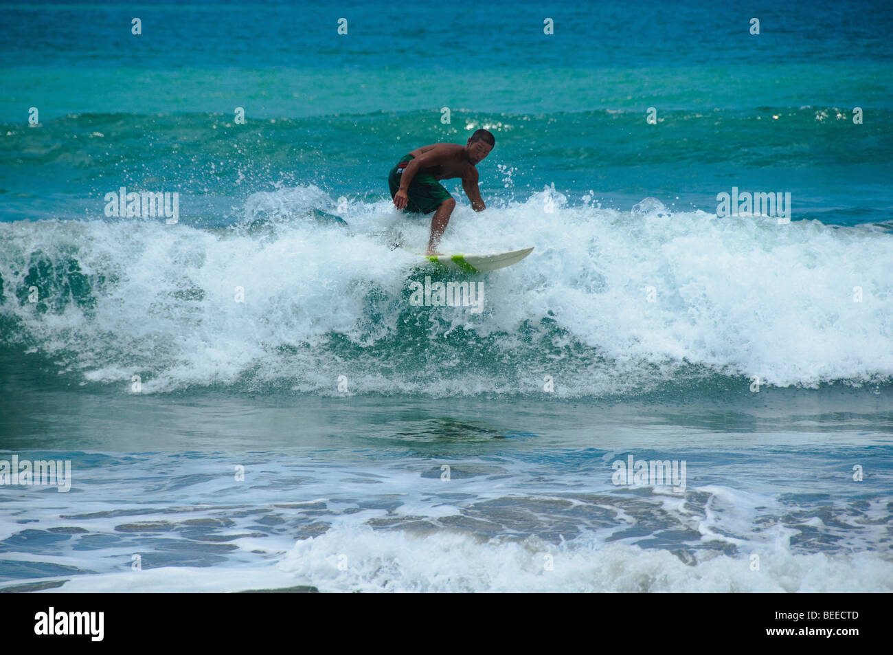 Navigare le onde a Kuta Beach a Bali Indonesia Foto Stock