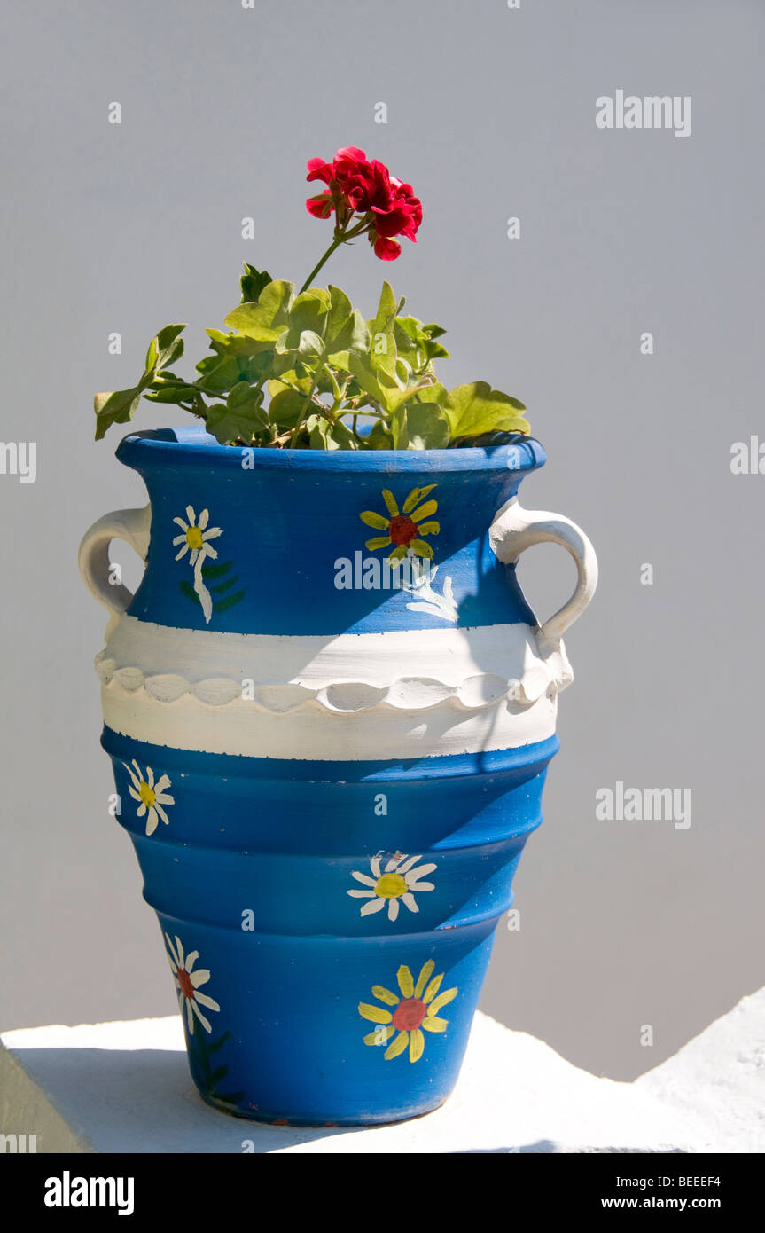 Vaso fiore greco bianco e blu con geranio su gradini di casa nella città vecchia sull'isola di Alonissos, Sporadi, Isole greche, Grecia Foto Stock