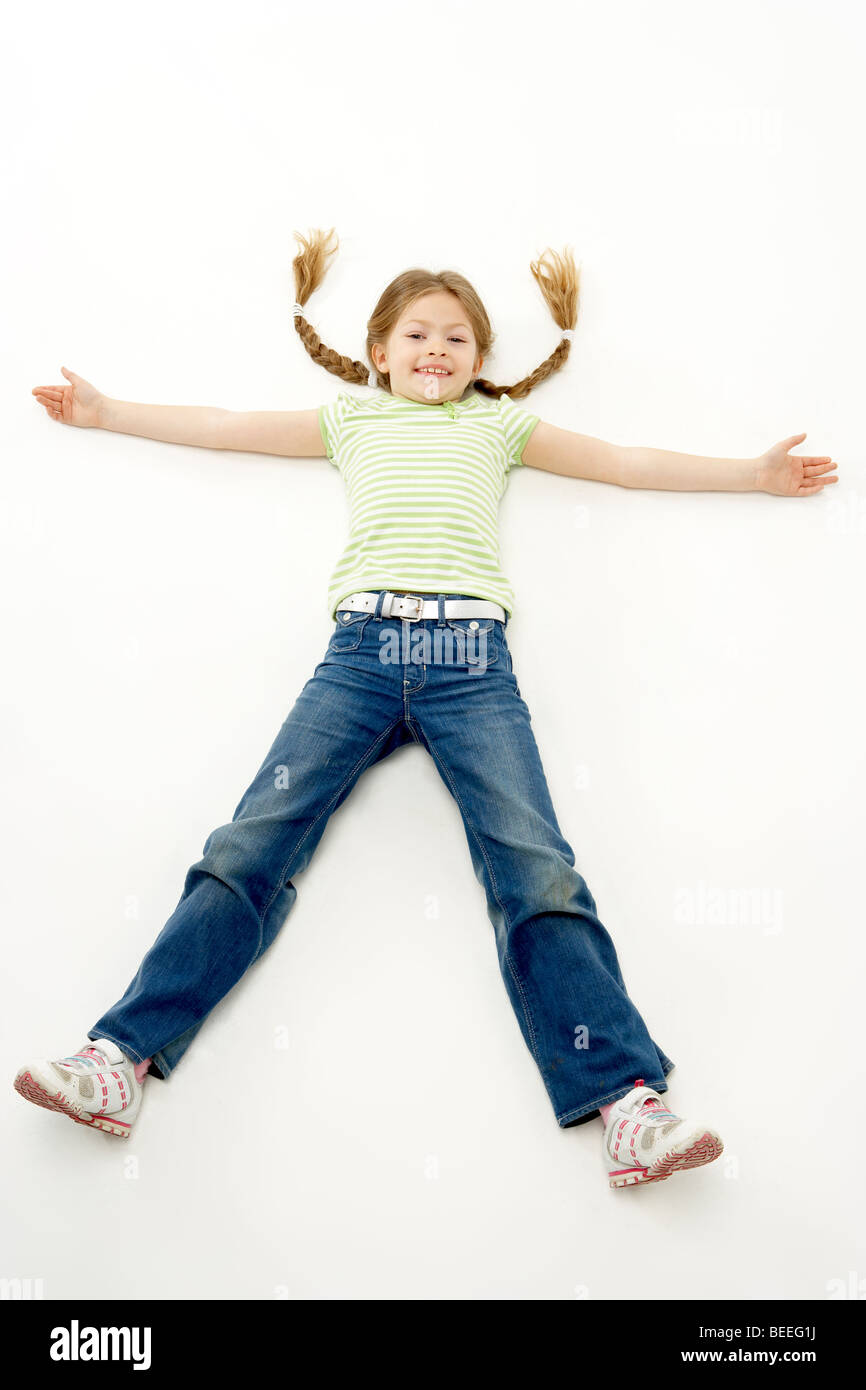 Ritratto in studio della ragazza sorridente sdraiato con le braccia e le gambe diffusione Foto Stock