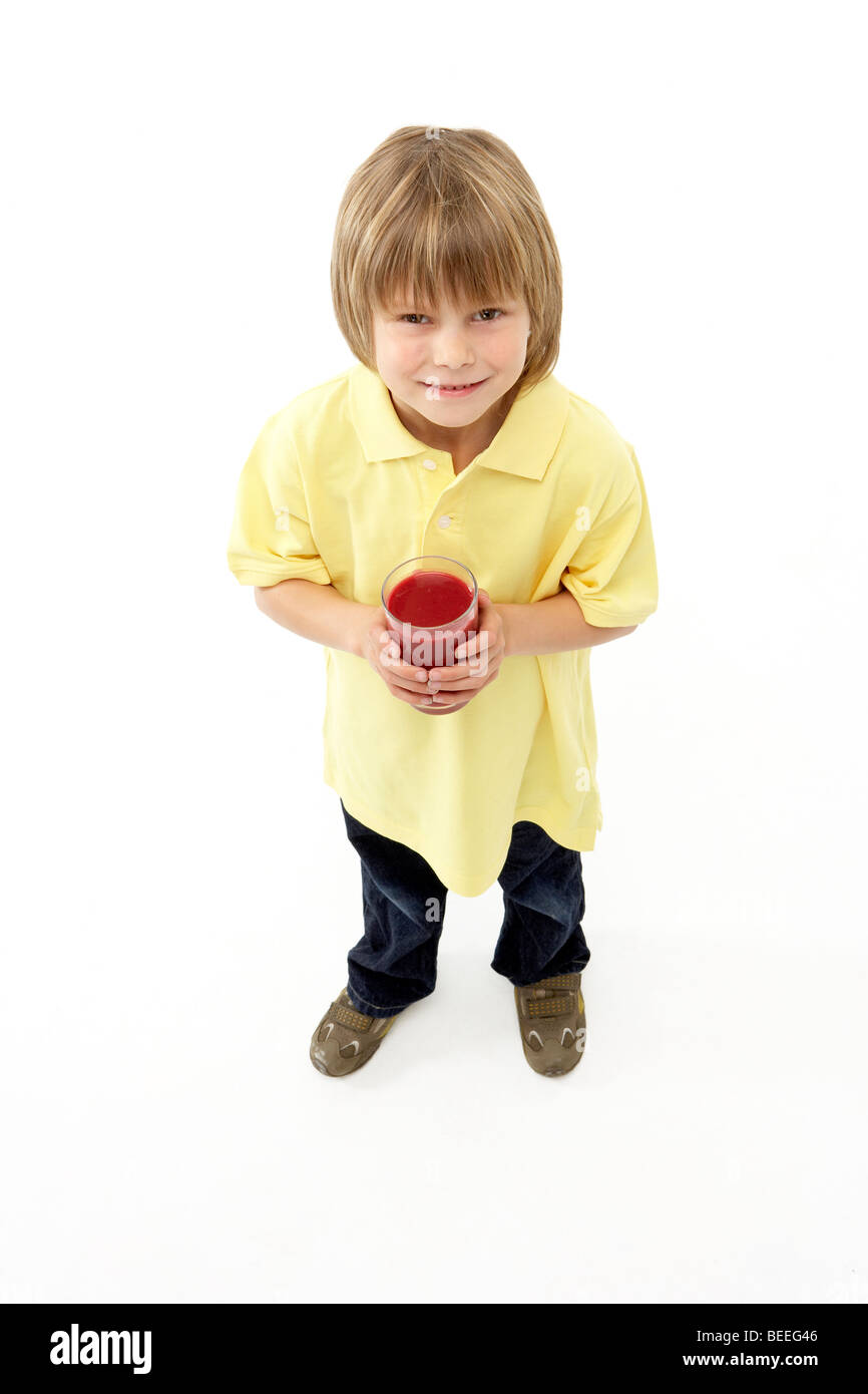 Ritratto in studio di sorridere Boy tenendo un bicchiere di succo di frutta Foto Stock