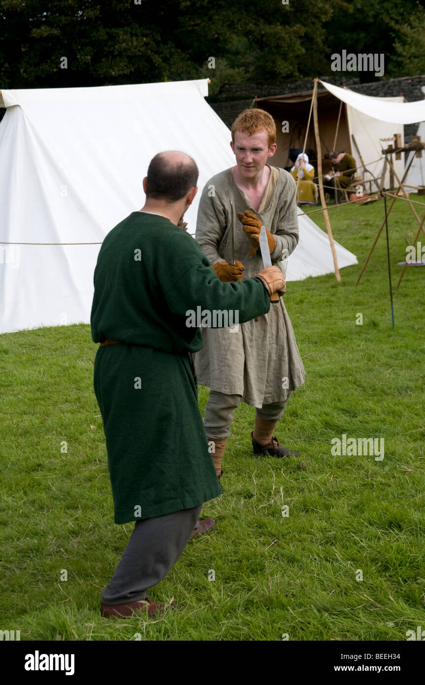 Medievale inglese re-enactors lotta con la spada sul display in Castleton nel distretto di Peak Derbyshire Inghilterra Foto Stock