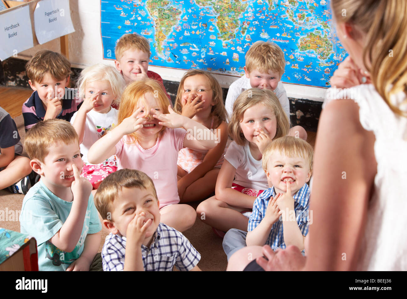 Montessori/Pre-School classe ascoltando insegnante sui tappeti Foto Stock
