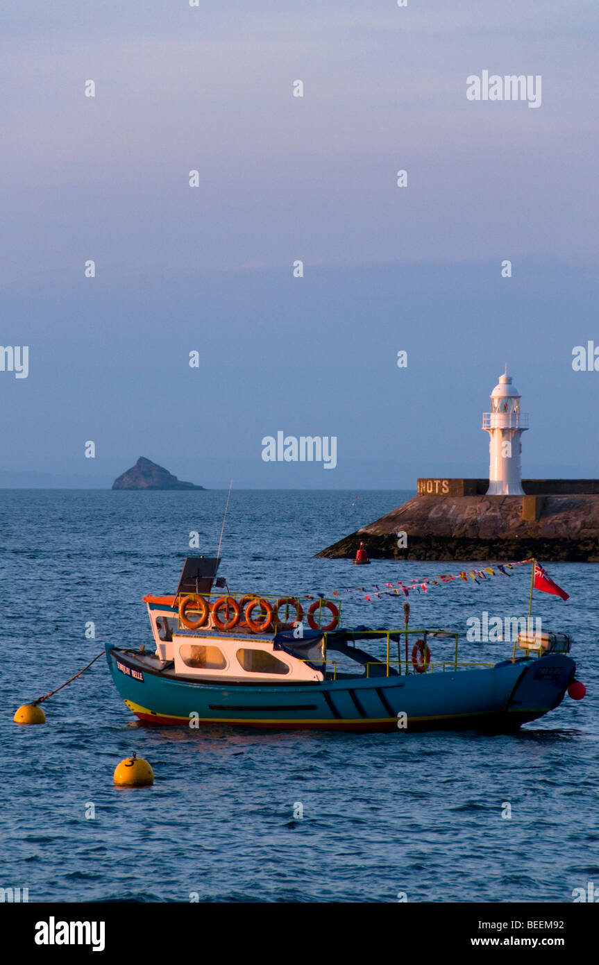 Faro e in barca al tramonto, Brixham, Devon, Regno Unito Foto Stock