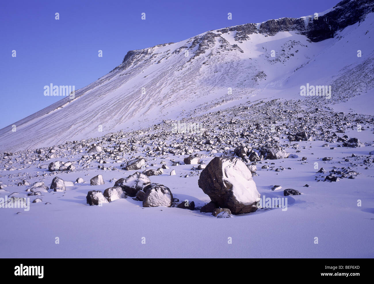 Coperta di neve rocce, frane, Islanda Foto Stock