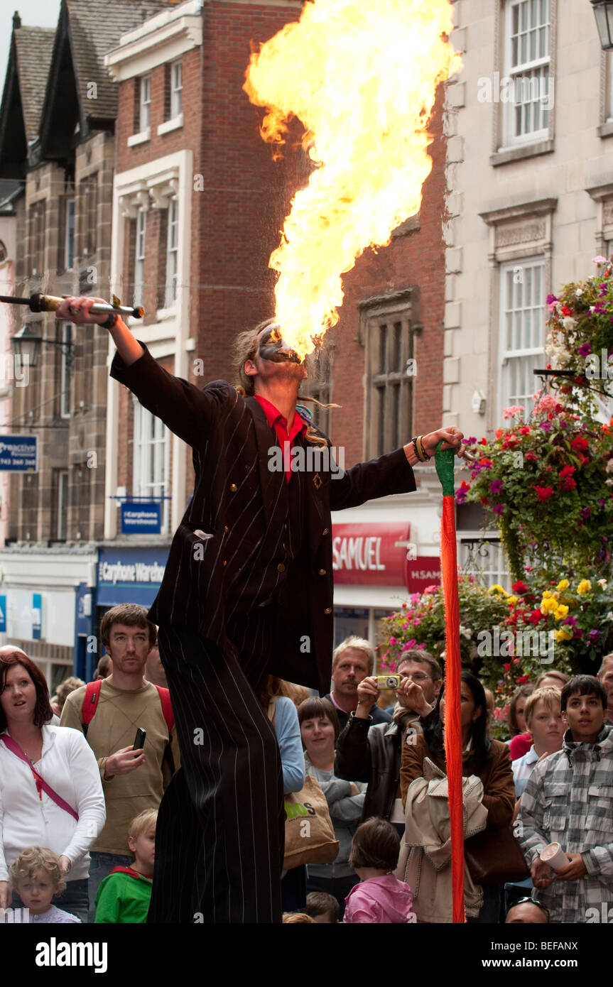 Stilt walker respirando fuoco a Shrewsbury Street Festival di Teatro Shropshire Foto Stock