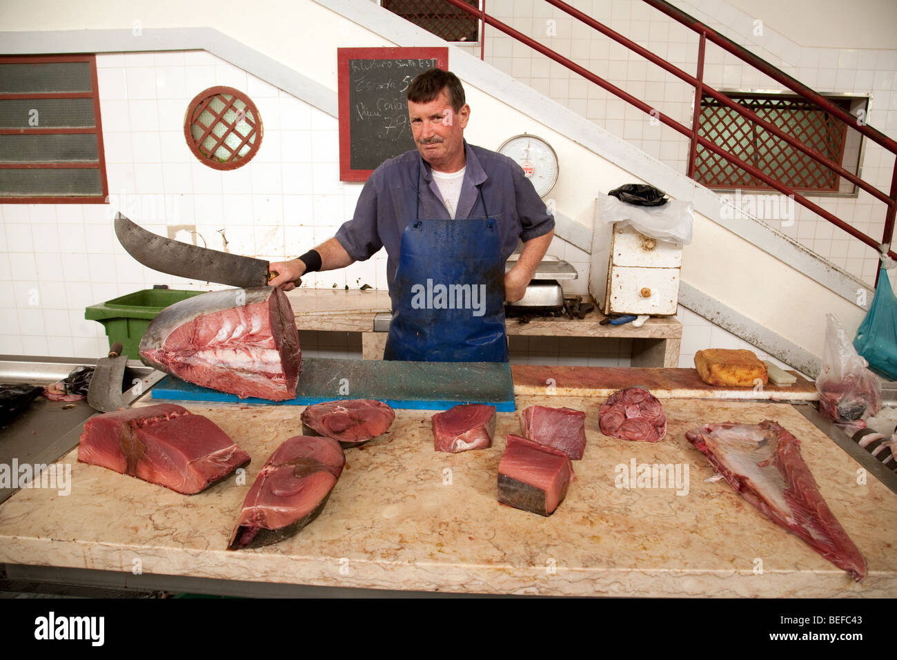 Pescivendolo con il suo tonno, il mercato, Funchal, Madeira Foto Stock