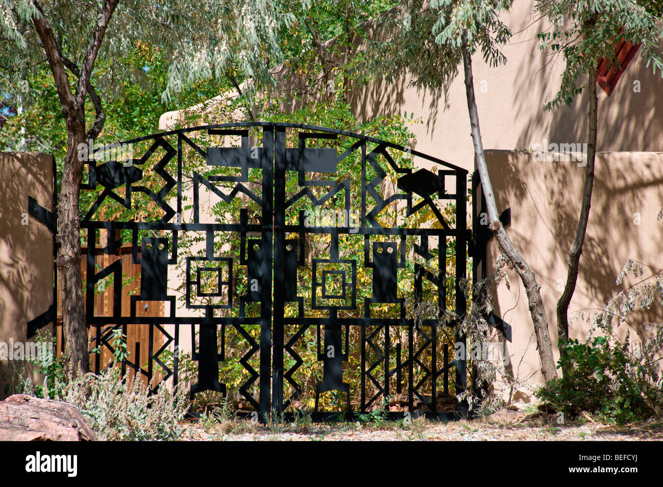 Un stile southwest cancellata in ferro battuto si chiude l'entrata di un elegante casa adobe a Taos, Nuovo Messico. Foto Stock