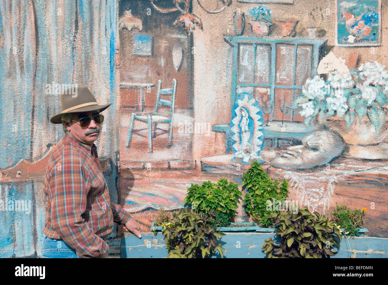 Un visitatore si ferma da una parete esterna murale di arti e mestieri città di Arroyo Seco, Nuovo Messico. Foto Stock