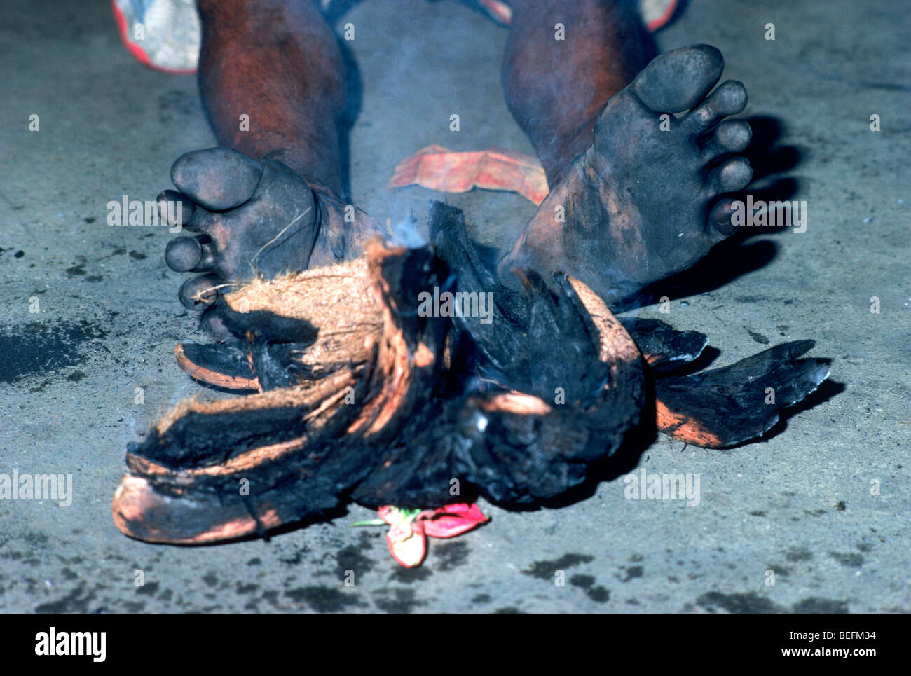 Trance maschio ballerino nero piedini bruciati sull isola di Bali in Indonesia dopo aver camminato attraverso il fuoco e la masterizzazione di noci di cocco Foto Stock