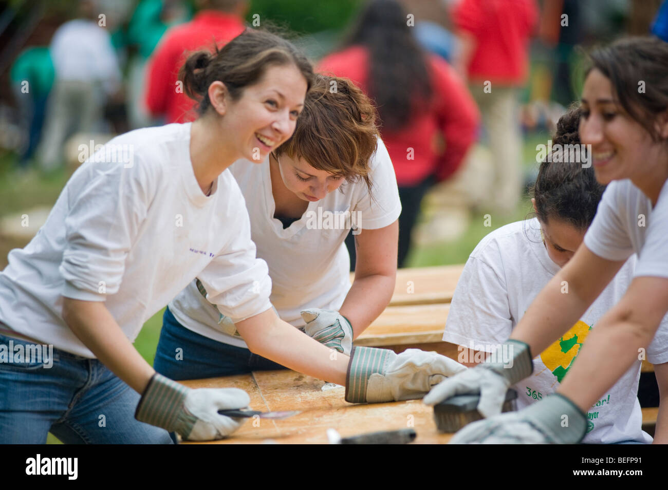 Volontario di Harvard Pilgrim Health Care partecipa in una città anno progetto per ristrutturare una parte interna della città di Boston scuola di charter. Foto Stock