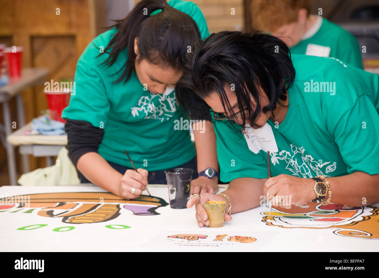 Volontario di Harvard Pilgrim Health Care partecipa in una città anno progetto per ristrutturare una parte interna della città di Boston scuola di charter. Foto Stock