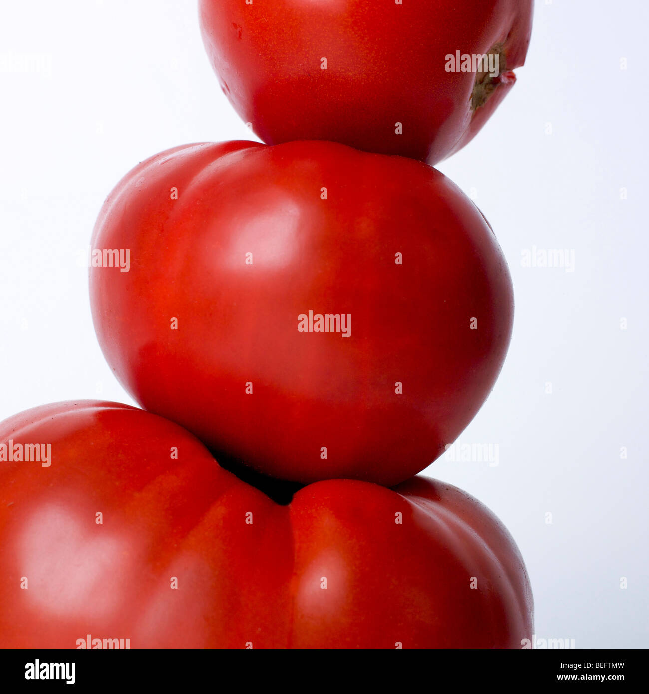Tre i pomodori su sfondo bianco in studio. Foto Stock