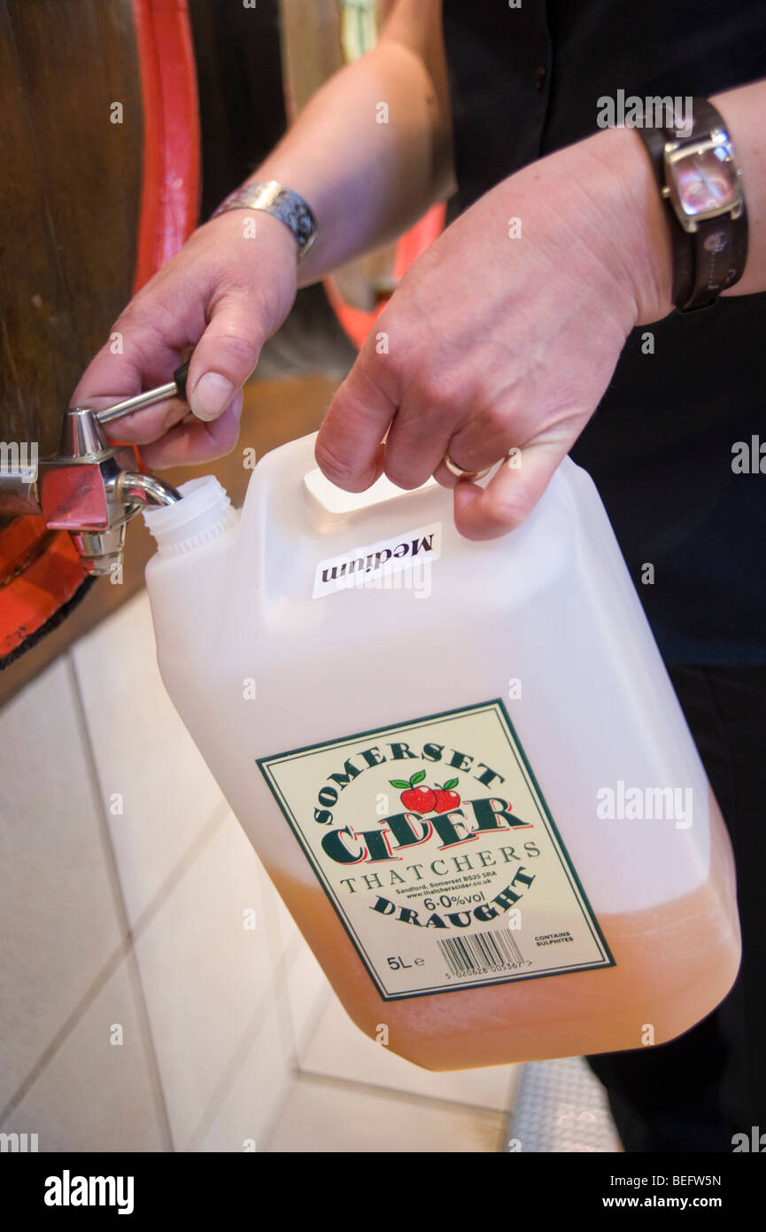 Il riempimento di un contenitore di plastica con il sidro di mele a Thatchers Sidro, sidro Thatchers Farm. Sandford, North Somerset, Inghilterra Foto Stock