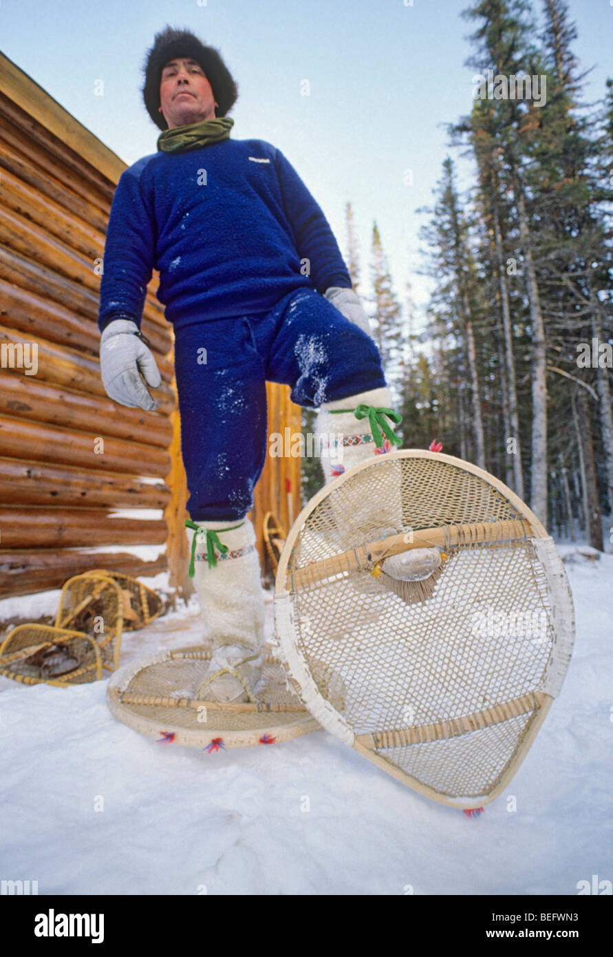 Uomo locale mostra off Labrador nativo (Indian) in stile con le racchette da neve, che è più rotondo rispetto a quelli usati da non nativi. Foto Stock