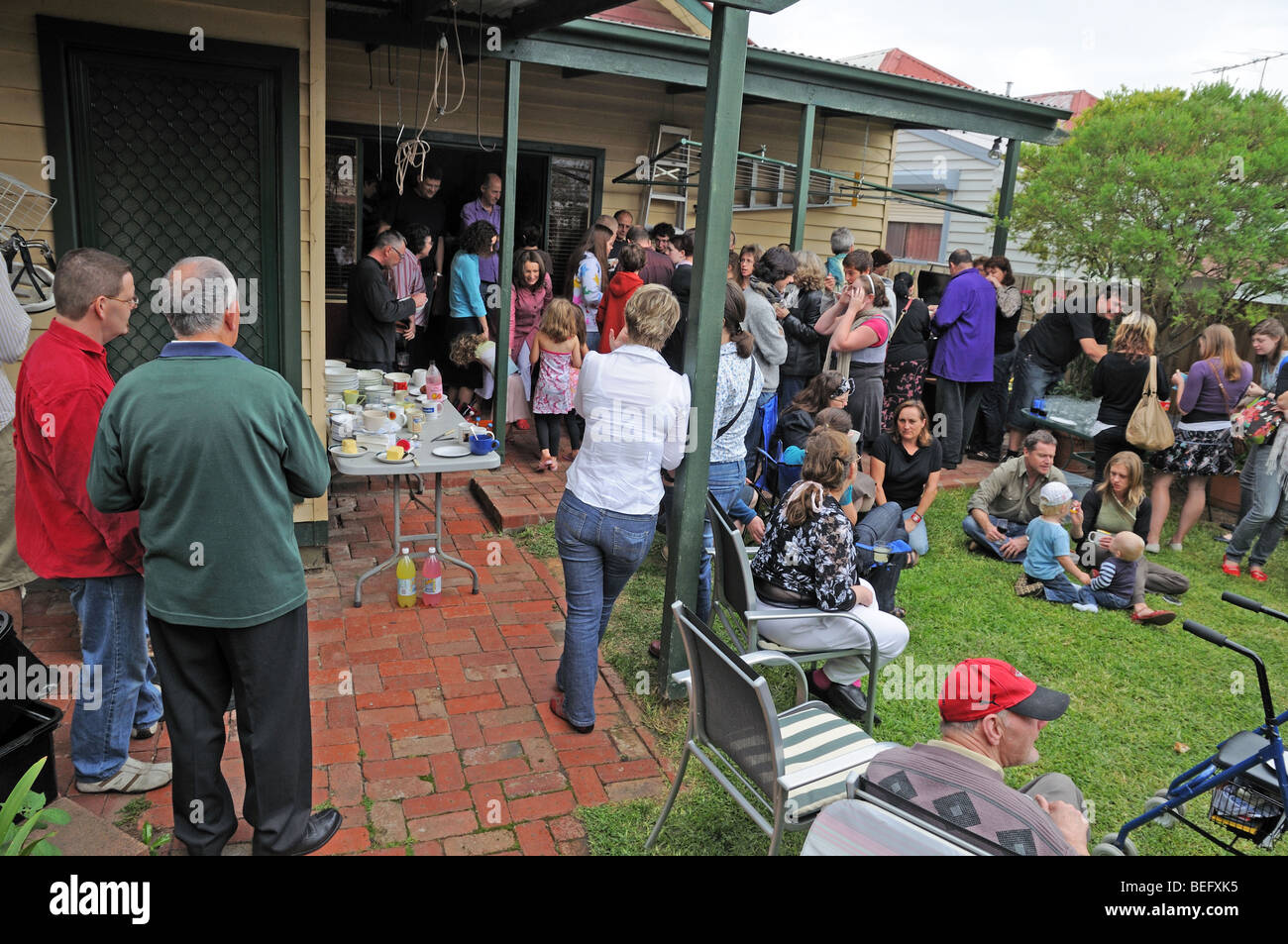 Gli australiani godendo la Domenica di Pasqua con un ora di pranzo parte di Hot Cross panini e bevande in una casa privata e giardino Foto Stock