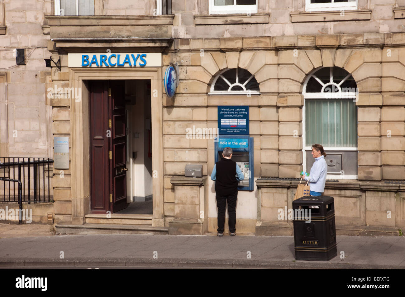 Alnwick, Northumberland, Inghilterra, Regno Unito. Barclays Bank con persona utilizzando il foro nella parete ATM Foto Stock