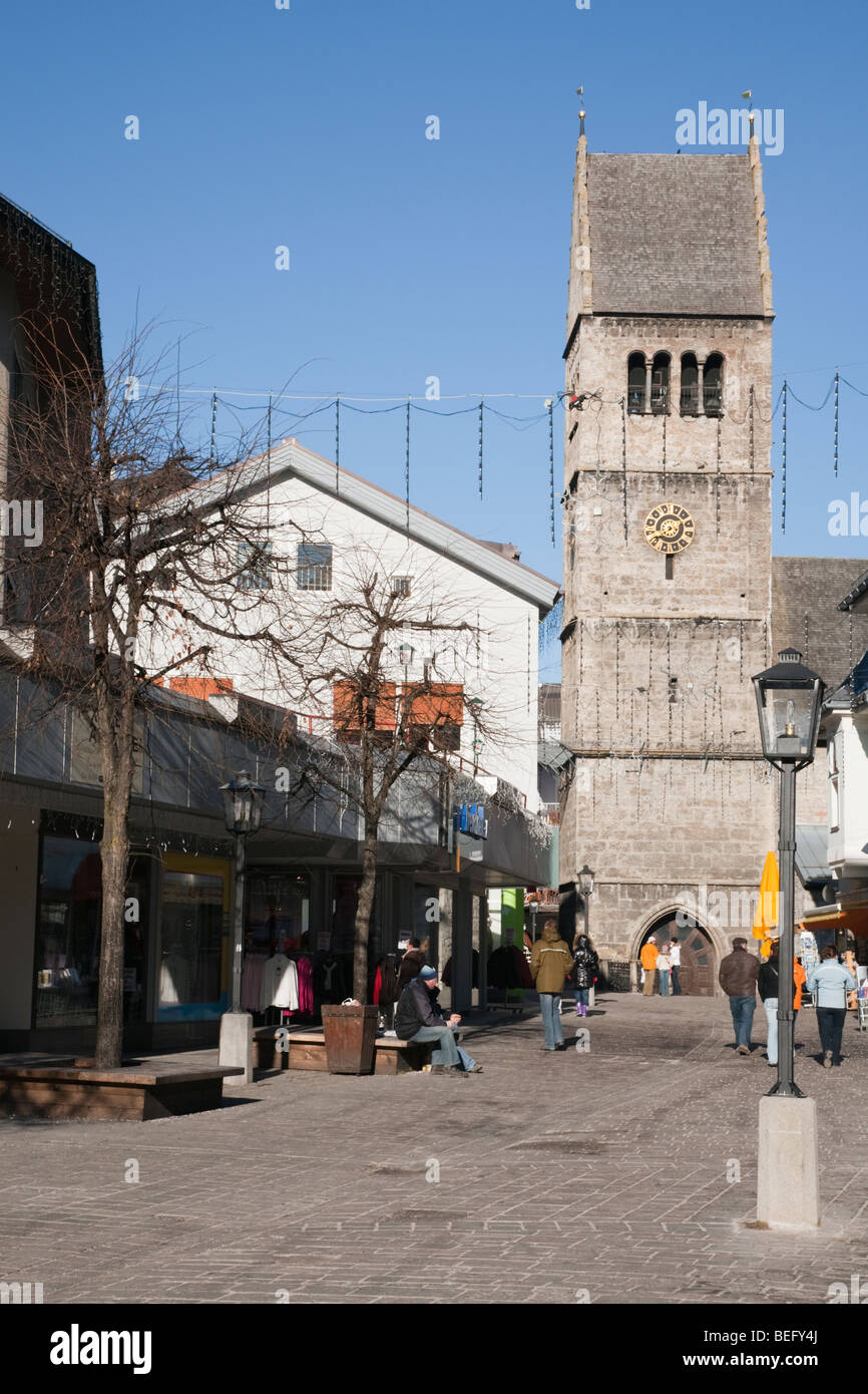 Zell am See, Austria. Vista lungo la zona pedonale High Street nel centro commerciale del centro di San Ippolito Chiesa parrocchiale di clock tower Foto Stock