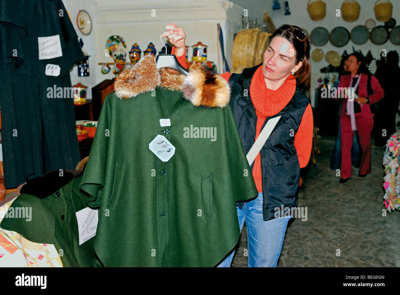 Portogallo Alentejo: Donna mostra rivestimento tipico "Capote Alentejano" in un negozio di artigianato in Serpa Foto Stock