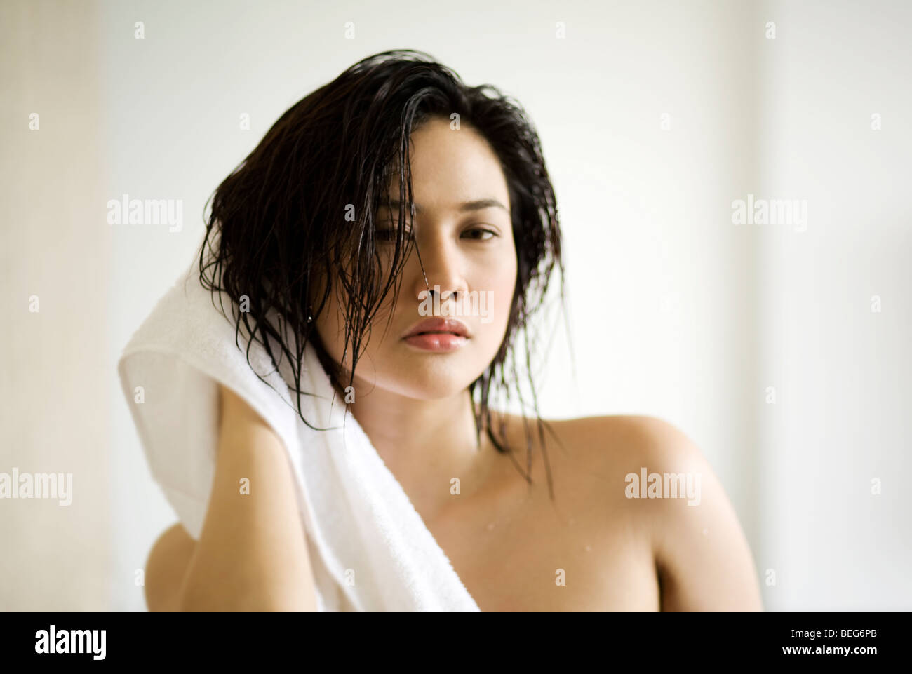 Ritratto di una giovane donna asciugando i capelli con un asciugamano Foto Stock
