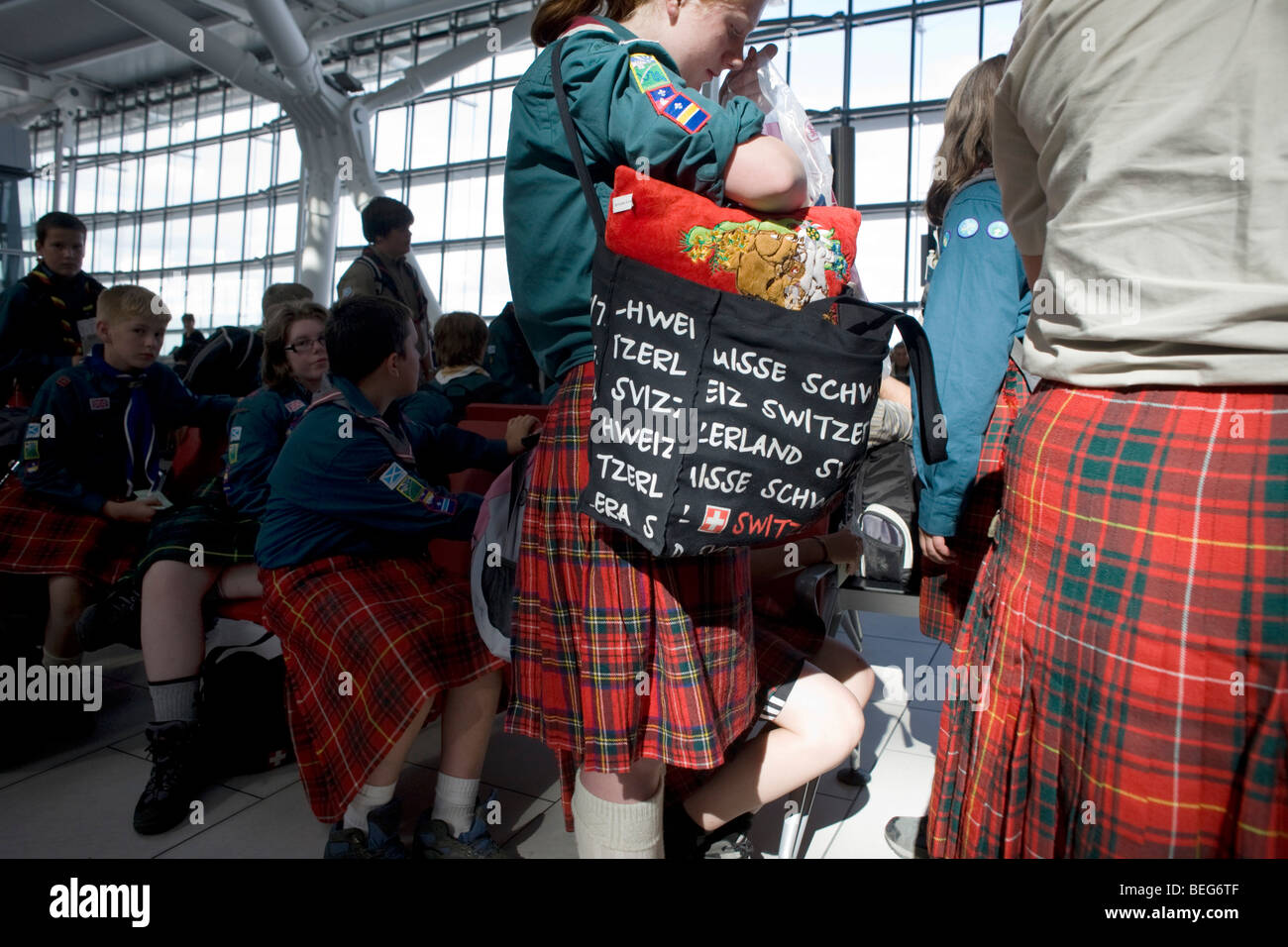 Scout scozzesi troupe passeggeri attendono il loro volo in partenza all'aeroporto di Heathrow il Terminal 5. Foto Stock