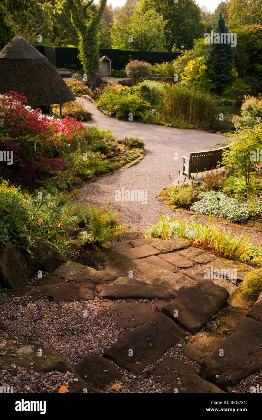 Un serpeggiante sentiero di ghiaia attraverso impianti a Ness Giardini Botanici nel villaggio di Ness nel Cheshire, Regno Unito Foto Stock